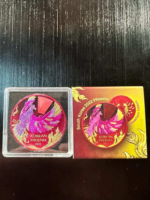 A 2022 Korean Phoenix HoloFlare Edition coin with a Mintage of only 250 and red and pink design on it.