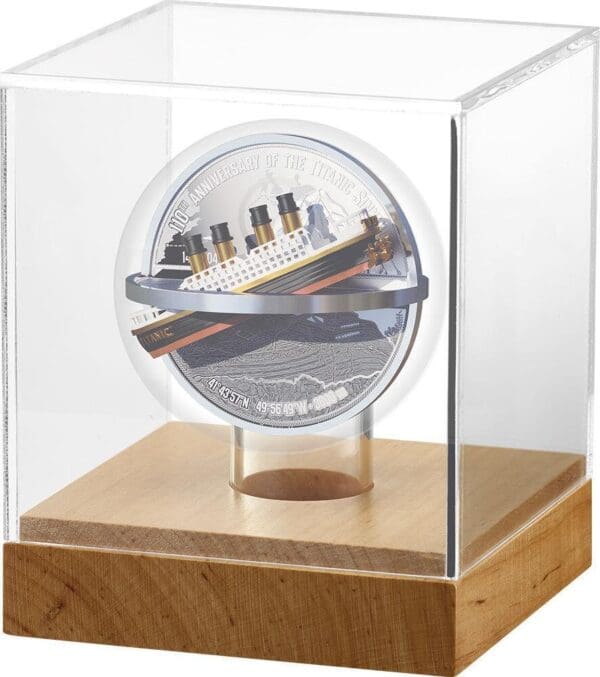 A commemorative 2022 Niue Titanic Catastrophe 100th Anniversary 2oz Silver Antique Proof Coin displayed in a clear protective case with a wooden base, celebrating 100 years of the Titanic.