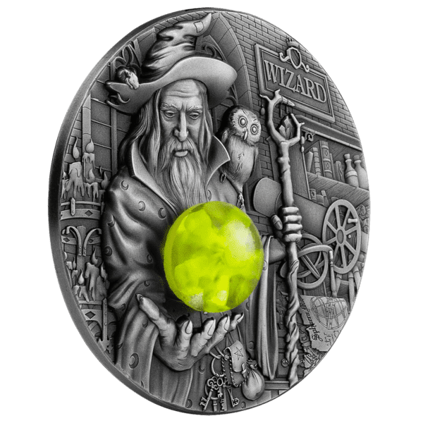 An intricate 2023 Cameroon Wizard 2oz Silver High Relief Antiqued Coin w/3D Insert with Mintage of 888 illustration of a wizard holding a glowing green orb with magical and medieval motifs in the background, showcasing the wizard's profound power.